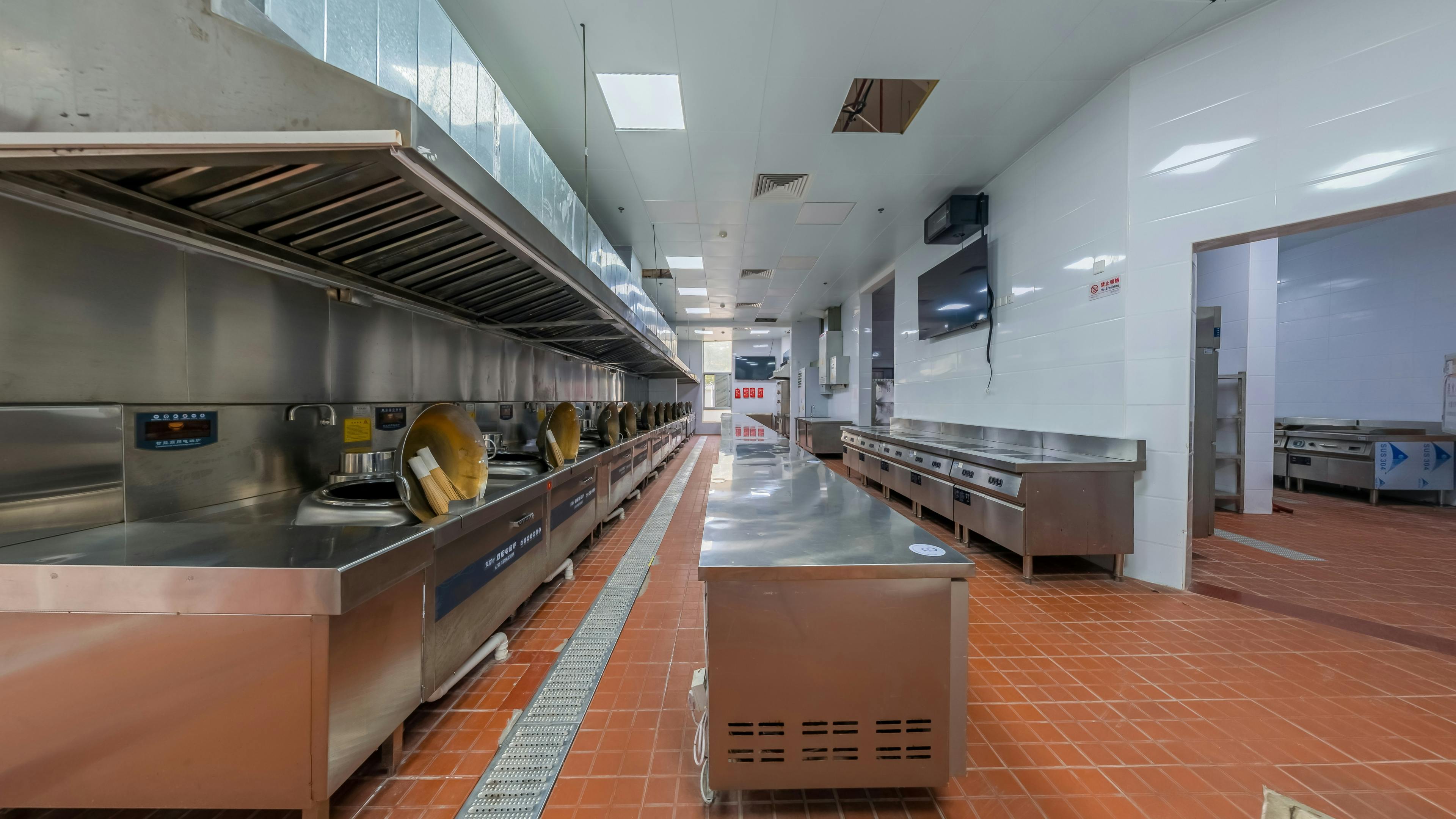 High-volume school kitchen line with stainless steel counters and cooking equipment