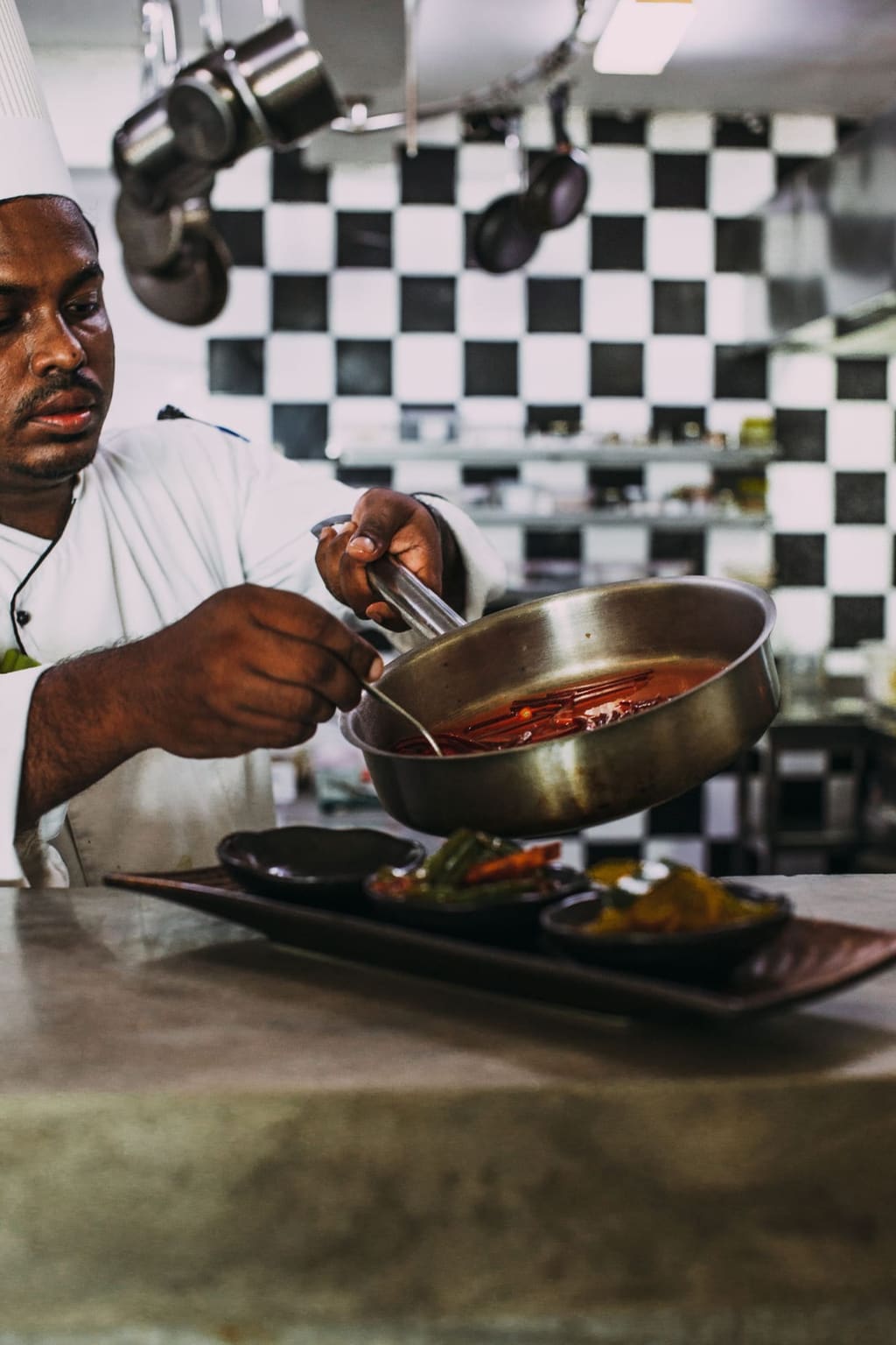 Chef cooking over open flames on a commercial cooking range